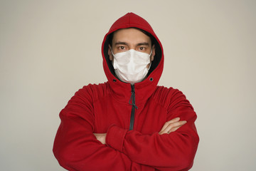 A man in a white medical mask in red clothes on a white background