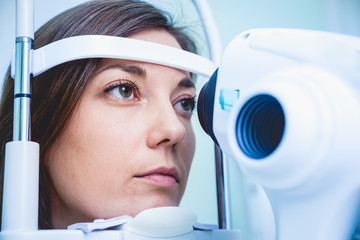 Doctor examining woman's eyes with a measurement machine.
