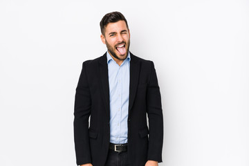 Young caucasian business man against a white background isolated funny and friendly sticking out tongue.