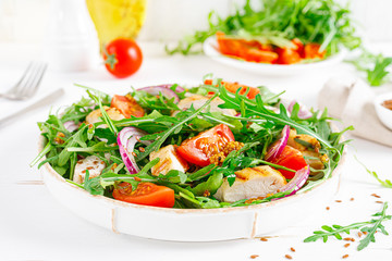 Fresh vegetable salad with grilled chicken fillet, breast, tomato and arugula