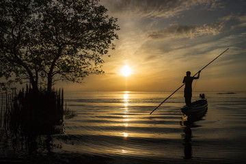 Silhouette of man with sunrise sky background, livelihoods of fishermen in Thailand