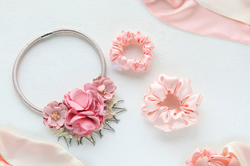 Pink hair accessories withroses. silk Pink Scrunchy isolated on white backdrop. Flat lay Hairdressing tools and accessories as Color Hair Scrunchies, Elastic HairBands, Bobble Scrunchie Hairband