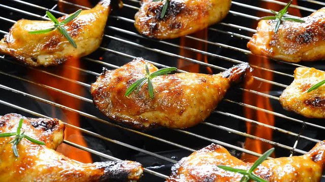 Grilled chicken on the flaming grill .