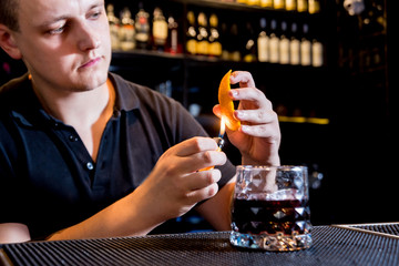 Bartender is making cocktail at bar counter. Fresh cocktails. Barman at work. 