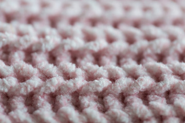 Pink knitted texture fabric wool, macro,close up blur background. Horizontal knitting