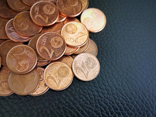 2 Euro cent coins on black. Selective focus. Copy space is on the right side.