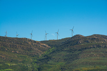 a farm of windmills in tarifa with the moon at the back