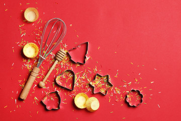 Baking utensils and ingredients.  Rolling pin, sugar sprinkling, whisk with cookie mold on a red background. Baking concept. Place for text.