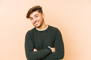 Young arabian man isolated on a beige background laughing and having fun.