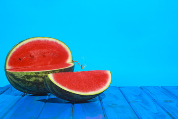 Sliced watermelon on a wooden table with a blue background. Summer concept