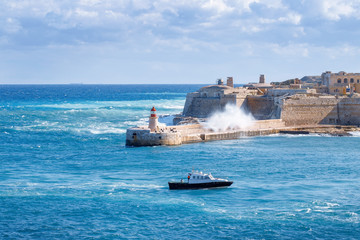 Ship in the sea. Big wave. Kalkara, Malta.
