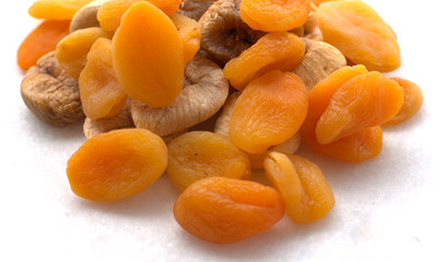 Dried figs  chocolates, peanuts  and apricots on white background