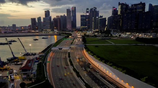 Aerial drone Hyper-lapse of City Skyline and highway traffic in Central Business District and port terminal, Singapore 2019.