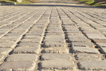 Paved road leading down a path