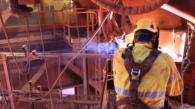 Footage of rope access welder wearing safety equipment, glove protection working on twin rope abseiling working fall arrest welding maintenance structures metal repairs on construction site, Perth