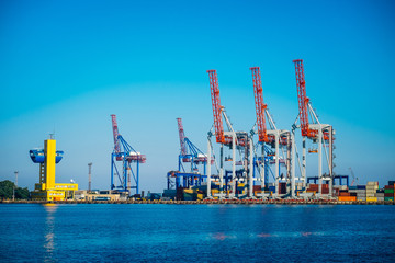 Obraz premium Black Sea trade port, containers loading by crane. International marine shipping. Container import export logistic, cargo harbor view, water transport. Industrial freight. Seaport cranes panorama.