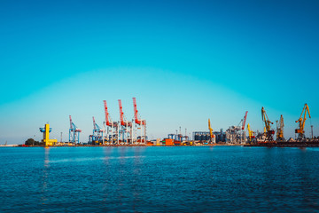Fototapeta premium Black Sea trade port, containers loading by crane. International marine shipping. Container import export logistic, cargo harbor view, water transport. Industrial freight. Seaport cranes panorama.