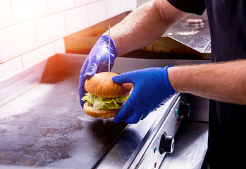Chef preparing burgers at the kitchen grill stove. Restaurant.