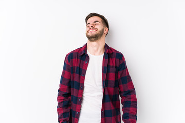 Young caucasian man posing in a white background isolated relaxed and happy laughing, neck stretched showing teeth.