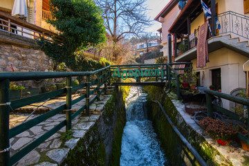 Fototapeta na wymiar Water stream in Agoriani or Eptalofos village, a winter destination near Parnassos mountain in Greece
