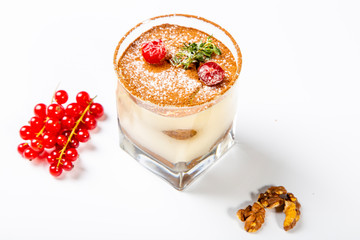 Panna cotta dessert in a clear glass. The dessert is decorated with powdered sugar and cranberry...