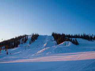 Dawn in the ski resort Mountain Salanga. Snowy slopes. Frosty morning in Siberia