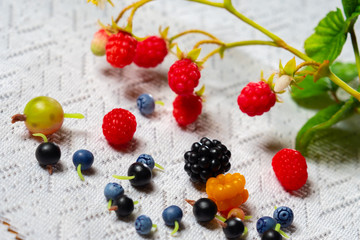 Forest and garden berries. Raspberry. Sea-buckthorn. Blueberries. Black currant. Gooseberry. Blackberry. Berries on white lace. Berries on the table.