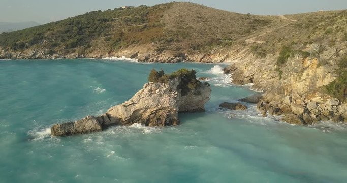 Aerial view of small beach with turquoise water next to rocks and trees in the area of Agia Paraskevi Halkidiki, Greece. View from drone	