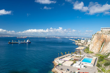 cargo ship off the coast of Gibraltar, a swimming stadium on the coast