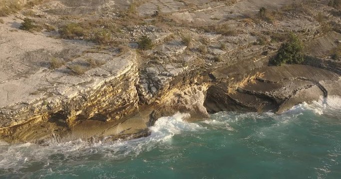 Aerial view of small beach with turquoise water next to rocks and trees in the area of Agia Paraskevi Halkidiki, Greece. View from drone	