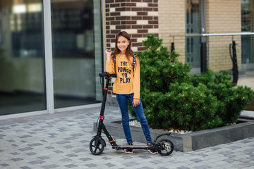 A young child girl riding in a city park on a gyroscooter. Resting on a weekend.