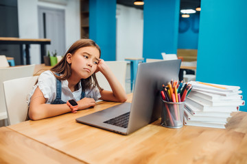 Portrait of unhappy little girl children using laptop computer, studying through online e-learning...