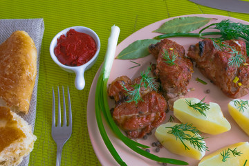 Plate with grilled meat skewers, bread, potatoes and spices. Harmful and hazardous food containing carcinogens.