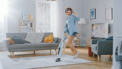 Shot of a Young Beautiful Woman in Jeans Shirt and Shorts Dancing and Vacuum Cleaning a Carpet in a...