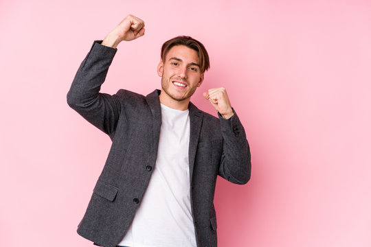 Young caucasian business man posing isolated celebrating a special day, jumps and raise arms with energy.