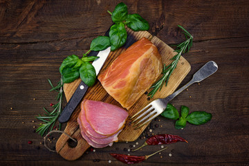 Sliced smoked pork meat with spices lies on an ancient cutting Board on a wooden rustic table...