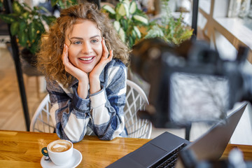 Portrait of smiling woman blogger in casual wear with cup of coffee