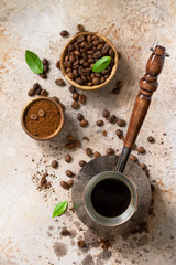 Obraz na płótnie Canvas Morning coffee concept. Turkish coffee in Turk and coffee beans on a stone or slate countertop. Top view flat lay background.