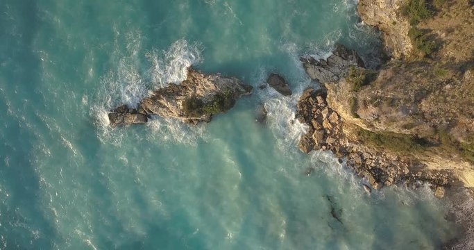 Aerial view of small beach with turquoise water next to rocks and trees in the area of Agia Paraskevi Halkidiki, Greece. View from drone	