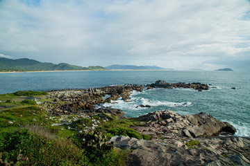 View of Armação beach shore line during the day. Rain clouds and sun. 