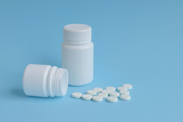 Cans of tablets on a blue background, concept of drugs, space for text