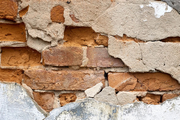 Part of an old red brick wall. Shabby building facade with damaged plaster. Grunge red stone wall background texture