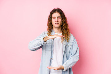 Long hair man posing isolated holding something with both hands, product presentation.