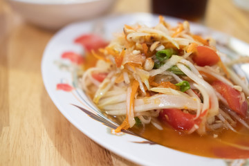 Close-up on Thai papaya salad on white plate