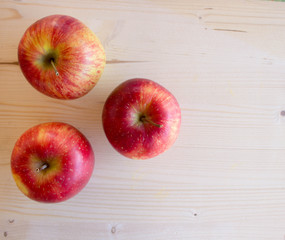 Red tasty Sicilian apples on the on the wooden background, top view. Healthy lifestyle, vitamins and Mediterranean diet.