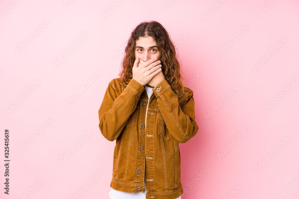 Wall mural Young long hair man posing isolated shocked covering mouth with hands.