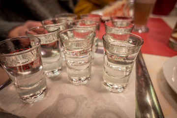 a table there is a small tray with several small glasses of alcohol on it