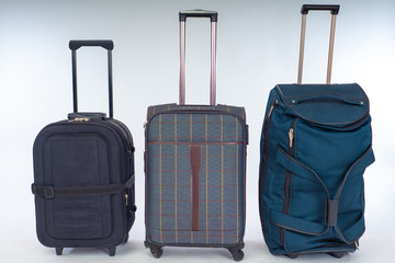 Suitcases and a bag on wheels are in the room. Suitcases with pull-out handles. Convenient transportation of personal items. Rules for baggage transportation.