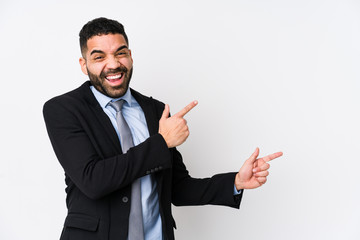 Young latin business woman against a white background isolated pointing with forefingers to a copy space, expressing excitement and desire.