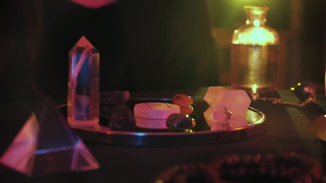 Close up of witchy hands putting the rune on the mirror while fortune spelling